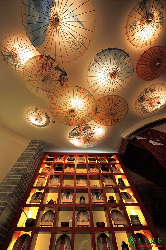 茶架上摆满茶品，顶灯江南花伞相映，其意境不尽使人无限遐想。